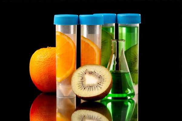 19152870 - lb tubes filed with liquid of with fruits parts on black background.